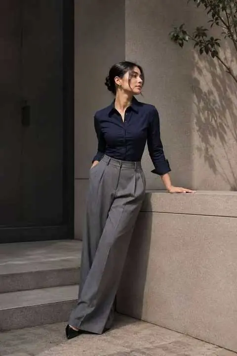 Woman in tailored navy shirt and grey trousers