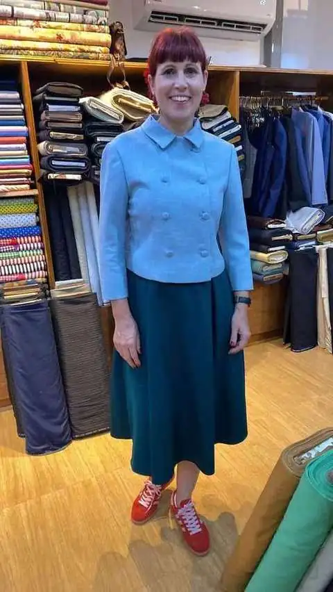 Client in light blue double-breasted jacket and teal midi skirt
