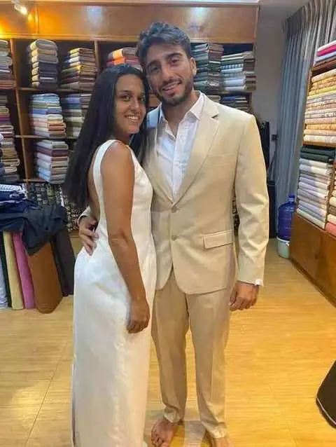 Couple dressed for a wedding, bride in white satin gown and groom in beige tailored suit