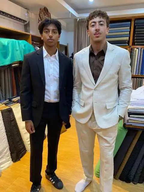 Two clients, one in a black tuxedo jacket and one in a cream linen suit
