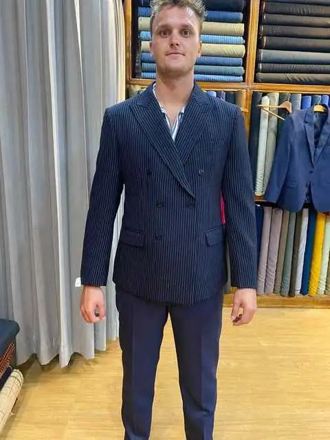 Client in navy pinstripe double-breasted blazer, close-up