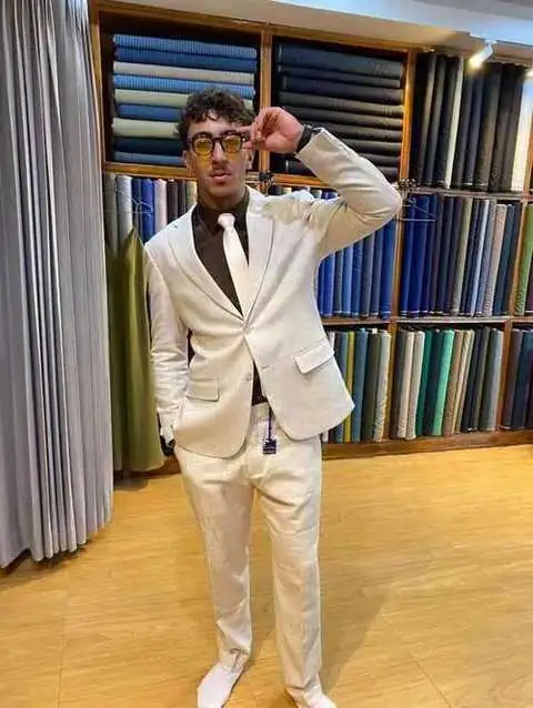 Client in cream linen suit with brown shirt and tie