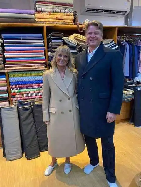 Couple in tailored coats, beige double-breasted coat and navy overcoat