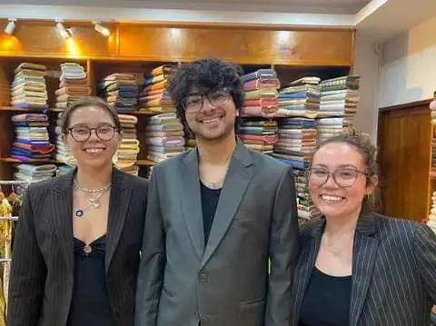 Three tailors in pinstripe blazers at the Paul Bespoke Tailor shop