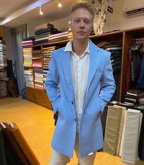 Client in light blue overcoat with white linen shirt