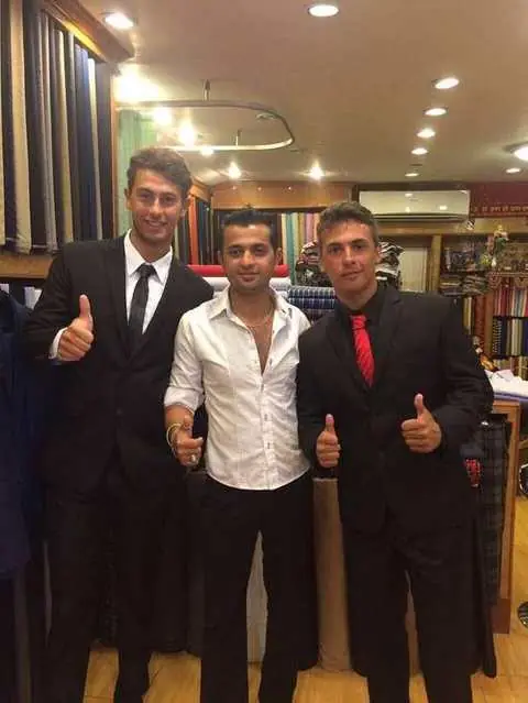 Three clients in black suits giving thumbs up