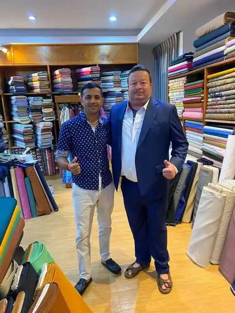 Two clients, patterned blue shirt and navy suit, giving thumbs up