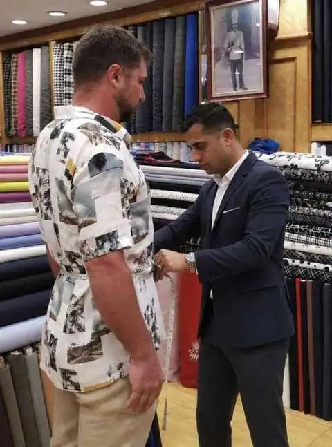 Tailor measuring a customer at Paul Bespoke Tailor